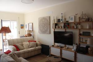 a living room with a couch and a flat screen tv at Number 10 Beach House in A dos Cunhados