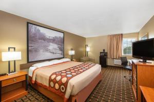 ein Hotelzimmer mit einem großen Bett und einem Flachbild-TV in der Unterkunft Super 8 by Wyndham Ottawa in Ottawa