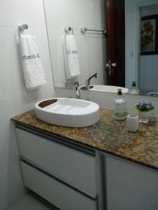 encimera con lavabo y espejo en Apart Hotel em Ondina Salvador, en Salvador