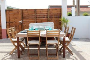 a wooden table with chairs and a white table cloth at Number 10 Beach House in A dos Cunhados