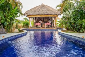 a swimming pool at a resort with a gazebo at United Colors of Bali in Canggu