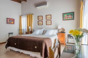 1 dormitorio con 1 cama y un jarrón de flores en Hotel del Antiguo Convento en Salta