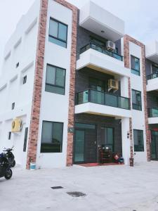 un condominio con una moto parcheggiata di fronte di Aegean Sea Homestay a Magong