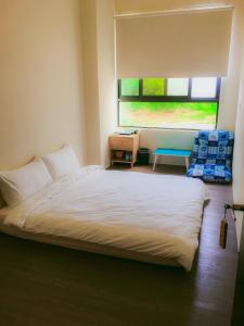 馬公市的住宿－愛琴海民宿，卧室配有白色的床和窗户。