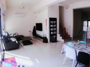 un soggiorno con un tavolo e una televisione di Aegean Sea Homestay a Magong