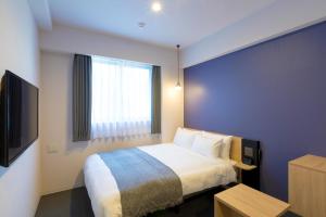 a hotel room with a bed and a window at M's Hotel Kyoto Station Taruya in Kyoto