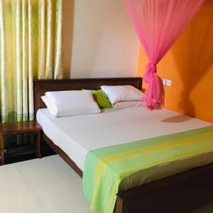 a bedroom with two beds with a pink curtain at Bee Nest Bed & Breakfast in Negombo