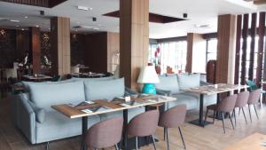 ein Restaurant mit Tischen und Stühlen und einer Couch in der Unterkunft Roxy Hotel Padungan in Kuching