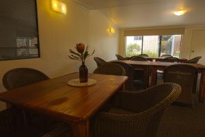 a dining room table with a vase of flowers on it at Surfpoint Resort in Margaret River Town