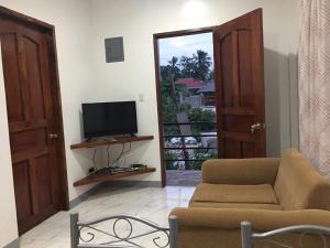 Villa Kendra في موالبوال: غرفة معيشة بها أريكة وتلفزيون