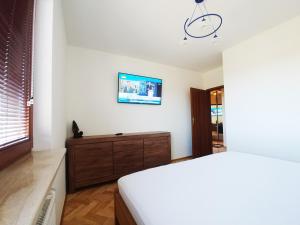 um quarto com uma cama e uma televisão na parede em Apartament, Kwatera Prywatna MARINA z garażem tarasem i wifi, blisko plaży, na przeciwko Parku Reagana em Gdansk