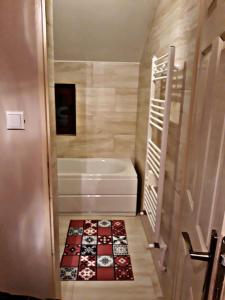 bagno con vasca e pavimento piastrellato. di La Curtea Veche a Lăpuş Altre 62 foto