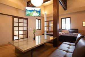 uma sala de estar com uma mesa e um sofá em Nachiya em Quioto
