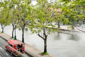 ein roter LKW, der neben einem Wasserkörper parkt in der Unterkunft MiLa Thapae@Chiang Mai Old City in Chiang Mai