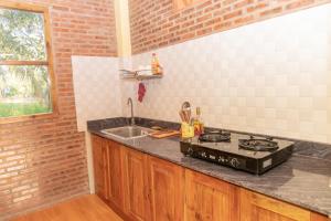 cocina con fogones y fregadero en Orchard Fruit Farm Bungalow en Phu Quoc