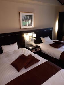 a hotel room with two beds and a picture on the wall at Forest Hotel Rochefort in Maniwa