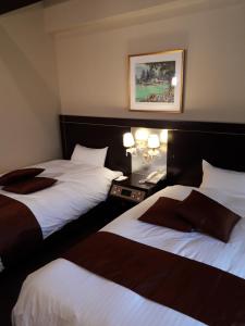 真庭市にある湯原温泉 森のホテル ロシュフォールのベッド2台が備わる客室で、壁に絵が描かれています。