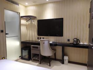 Habitación con escritorio, TV y silla. en Beauty Hotels - Hotel Bnight-Self Check-In Hotel, en Taipéi