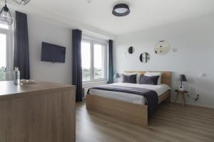 a bedroom with a bed and a tv on the wall at Uptown studio apartment in Vilnius
