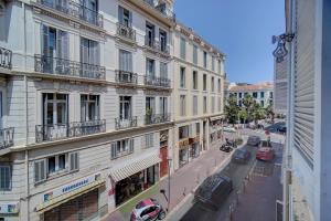 Blick auf ein Gebäude mit Autos auf einer Straße in der Unterkunft Sweet Home Marceau 6 studios hyper centre proche de la mer et du palais in Cannes
