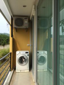 uma máquina de lavar roupa e uma máquina de lavar e secar roupa na varanda em Best Point Condominium Cape Panwa em Cidade Phuket