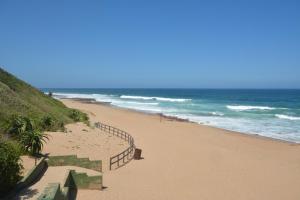 a sandy beach next to the ocean with a fence at IRONWOOD LODGE in Pennington