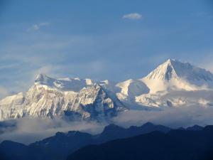 una montaña cubierta de nieve con nubes delante de ella en Le Glamour Resort & Wellness Spa, en Pokhara