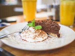ein Stück Schokoladenkuchen auf einem Teller auf einem Tisch in der Unterkunft Pension Nuernberg-Fuerth in Fürth