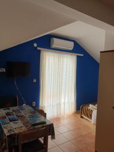 斯維斯托的住宿－Apartments Demo，一间设有窗户和桌子的蓝色墙壁客房