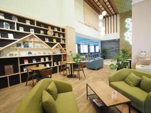 a living room with two couches and a table and chairs at Kailan Hotel in Toucheng