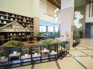 a lobby with chairs and plants on shelves at Kailan Hotel in Toucheng