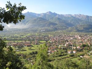een stad in een vallei met bergen op de achtergrond bij La Chiocciola...The Snail in Bussoleno