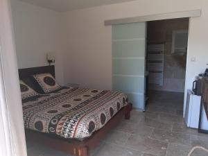 1 dormitorio con 1 cama y vestidor en Chambre d hôte piscine spa, en Alba La Romaine