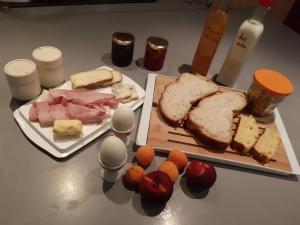 una mesa con dos platos de comida con pan y queso en Chambre d hôte piscine spa, en Alba La Romaine