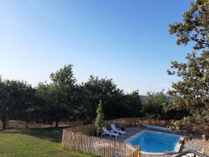 un patio trasero con piscina y valla en Chambre d hôte piscine spa, en Alba La Romaine