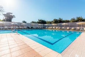 una grande piscina blu con sedie e ombrelloni di Dimitra & Evdokia Hotel ad Agia Marina Nea Kydonias