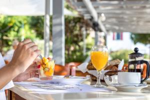 uma pessoa sentada à mesa com um copo de sumo de laranja em Alinda Hotel em Alinda mais 59 fotografias