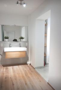 baño con lavabo blanco y suelo de madera en Koblenz Süd exklusive und zentrale Designer Wohnung, en Coblenza