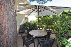 einen Tisch und Stühle mit Sonnenschirm auf einer Terrasse in der Unterkunft Il Villaggio Di Giuele in Finale Ligure