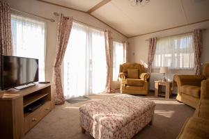 a living room with a bed and a television at Robin's Retreat in South Cerney