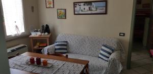 羅西尼亞諾蘇威的住宿－Appartamento Caletta，客厅配有沙发和桌子