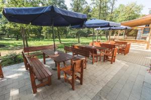 a group of wooden tables and benches with umbrellas at Pivovar a Penzion GRASEL in Český Rudolec