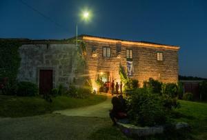 a group of people standing outside of a building at night at Casa do Pacio Sabadelle in Lugo +116 photos