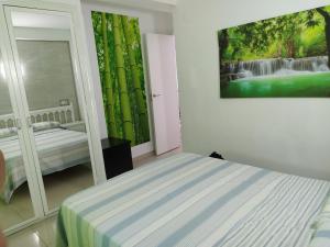 ロスピタレート・デ・リンファントにあるApartamento primera línea de marのベッドルーム1室(ベッド1台付)が備わります。壁には絵画が飾られています。
