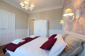 a bedroom with a large white bed with red pillows at A L'Aube de Troyes in Sainte-Savine +7 photos