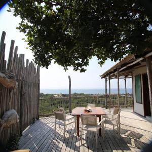 - une table et des chaises sur une terrasse avec vue sur l'océan dans l'établissement Tree House Villa, à Praia do Tofo