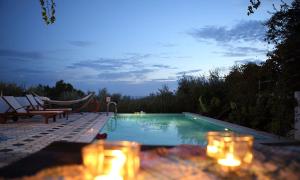 una piscina por la noche con velas delante en Euphoria - South Crete Villas, en Achlia