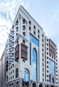 un edificio alto de color blanco con ventanas de cristal en Tulip Inn Al Daar Rawafid en Medina