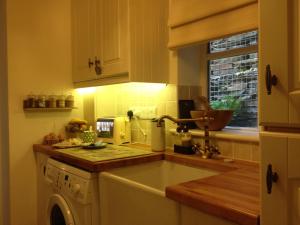 a kitchen with a sink and a dishwasher at Snowdonia Snug - Studio Style Accommodation in Dolgellau