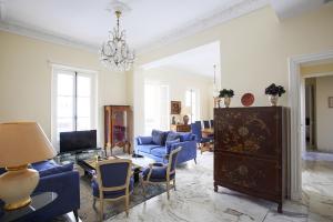a living room with blue furniture and a chandelier at Havre de paix au coeur de Cannes in Cannes